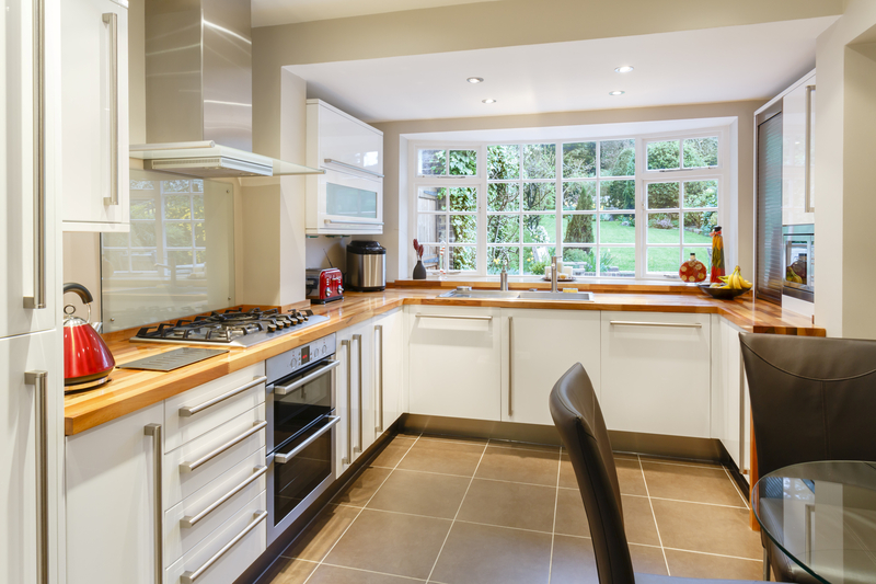 newly renovated kitchen with white cupboards and a wooden worktop